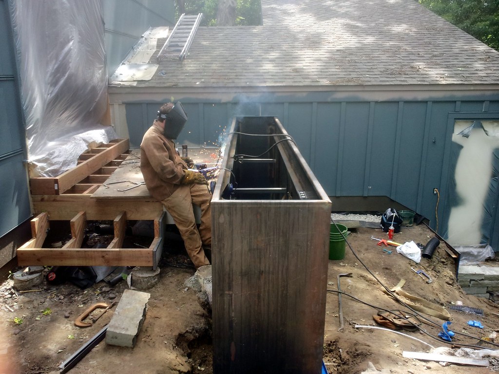 Welder fabricating a corten steel weathering planter box for a South Korea landscape project