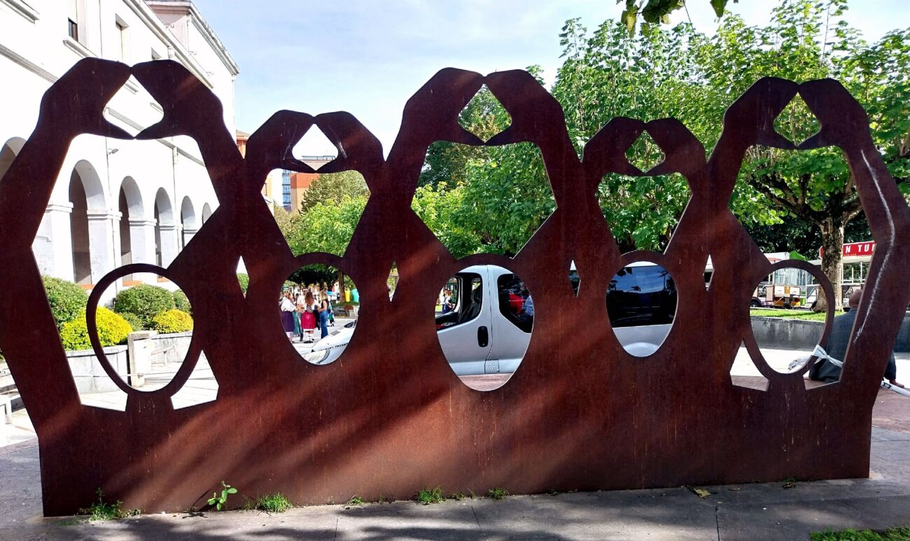 Cor-Ten steel screen sculpture with cut figures in a public plaza in Basauri, Spain