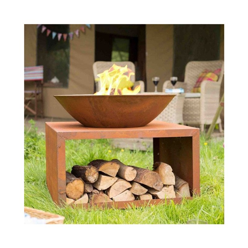 Weathered steel fire bowl with log storage stand outdoors