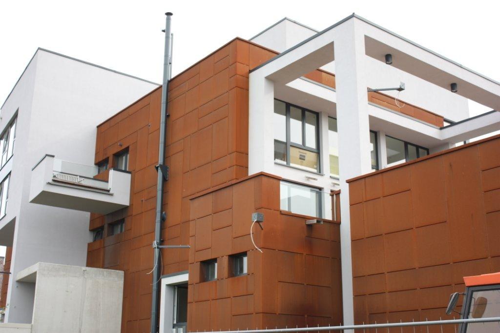 Real corten steel facade panels on a building with natural weathered patina