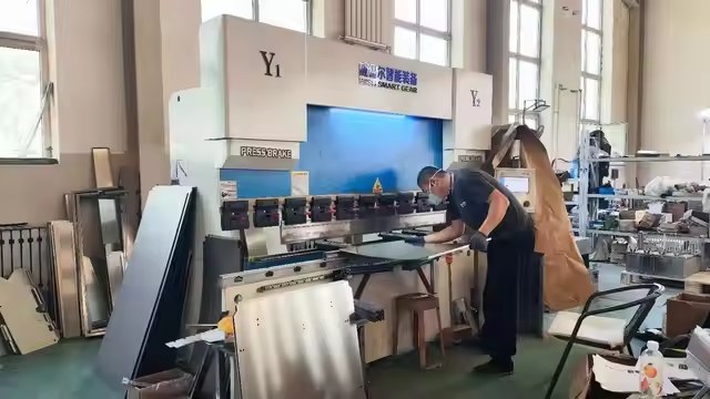 CortenFactory worker operating metal processing equipment